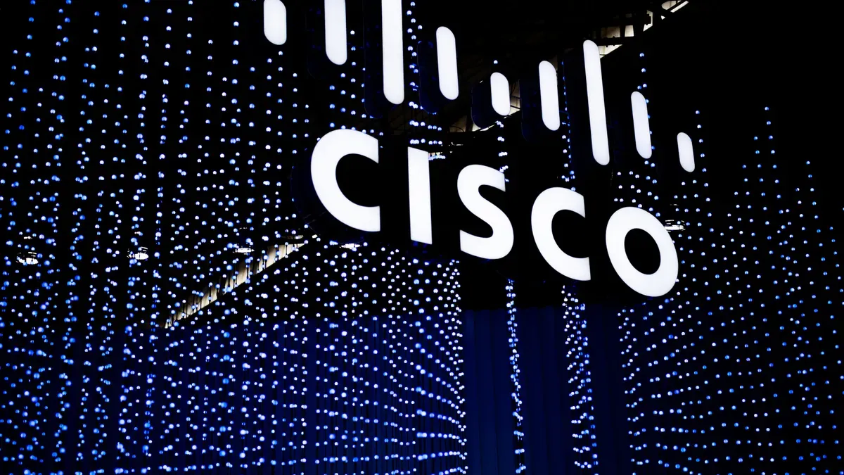 Логото на Cisco се вижда окачено във въздуха пред поредица от сини светлини