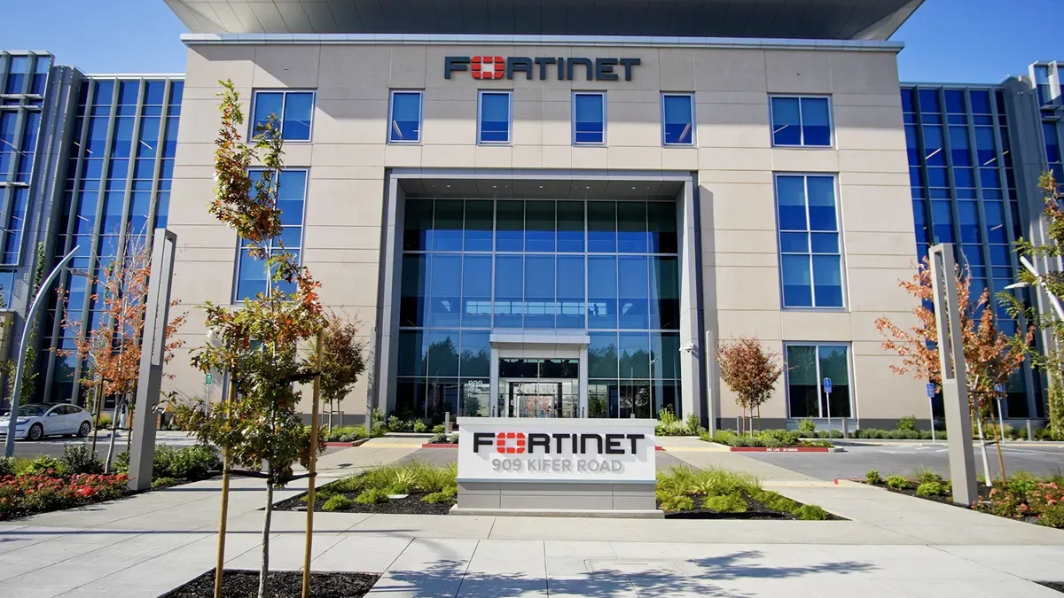 Сграда с големи стъклени прозорци носи лого на Fortinet в горната си част, докато табела на нивото на земята гласи „Fortinet - 909 Kifer Road“